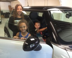 Tamara’s lovely family embracing their MINI called “Vanilla Ice Baby”  a 2010 MINI Cooper Chili In Ice Blue with Low Miles 14700 & Full Leather Seats