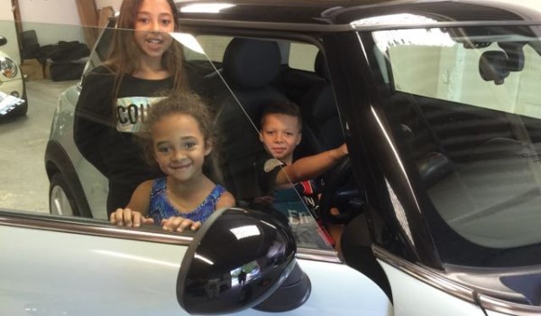 Tamara’s lovely family embracing their MINI called “Vanilla Ice Baby”  a 2010 MINI Cooper Chili In Ice Blue with Low Miles 14700 & Full Leather Seats